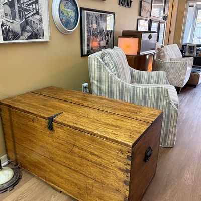Rustic wooden blanket chest with dovetail joints and black metal hardware.