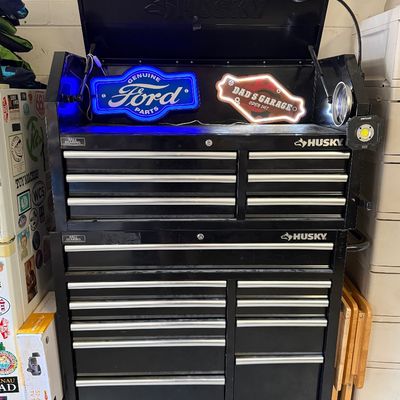 Husky black rolling tool chest combo with ball-bearing drawers, 

illuminated Ford Parts and Dad's Garage signs in the top compartment.