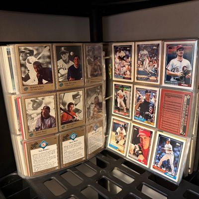 A collection of vintage baseball cards, including 1980s and 1990s Topps and Studio brands, organized in plastic pocket sleeves within a...