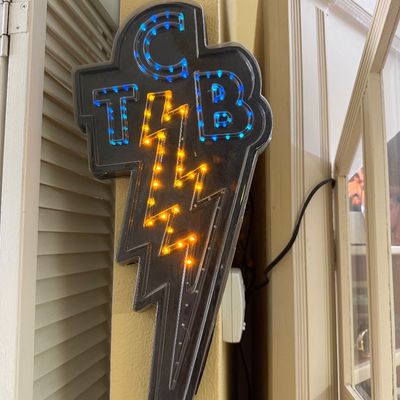 Elvis Presley "Taking Care of Business" (TCB) lightning bolt LED sign, featuring blue and yellow lights in a black plastic...