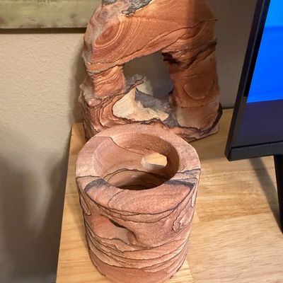 Two decorative Utah picture sandstone carvings, including a hollowed cylindrical piece and a natural arch formation.