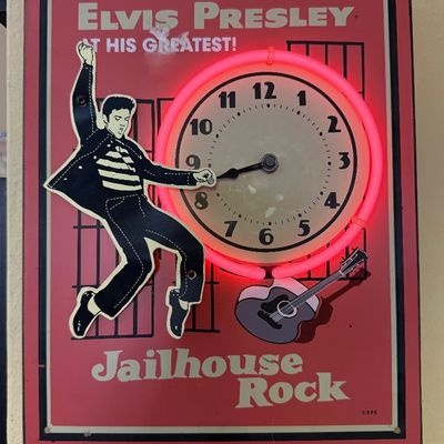 Vintage Elvis Presley "Jailhouse Rock" neon wall clock, featuring a dancing Elvis figure and a glowing pink neon ring around...