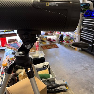 National Geographic telescope with a carbon fiber-style finish, mounted on a Bresser tripod.