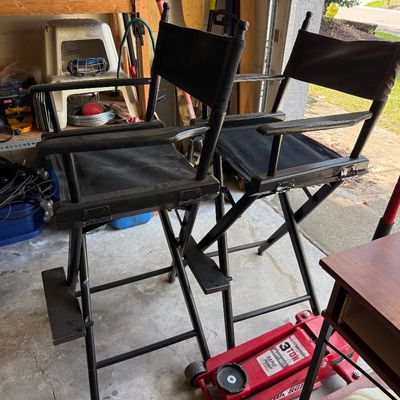 Pair of tall, black wooden director's chairs with black canvas seats and backs