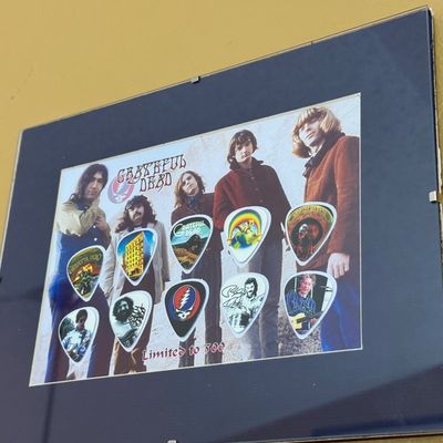 Framed Grateful Dead limited edition guitar pick display, featuring band member portraits and iconic album art designs, numbered...