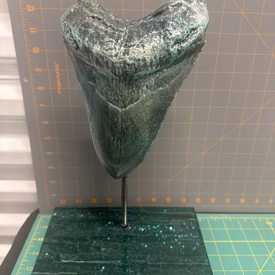 Plastic megalodon tooth replica with glittered resin stand