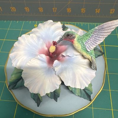 Four piece figurine set - elephant with flower. “Where’s my mom,”? Hummingbird on stained glass with hibiscus. Two cast castle, Hydro...