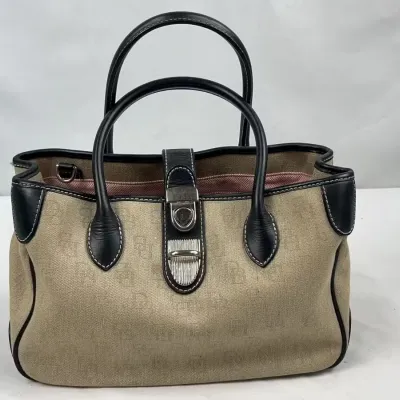 Dooney & Bourke signature monogram canvas handbag with black leather trim, dual rolled handles, and a silver-tone clasp closure.
