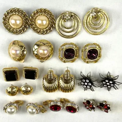 Collection of vintage costume earrings, featuring gold-tone clip-on and pierced styles with faux pearls, rhinestones, and colorful...