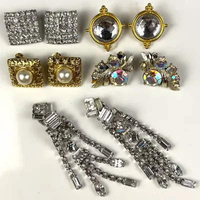 Collection of vintage clip-on earrings, featuring rhinestone, faux pearl, and aurora borealis crystal designs from the mid-to-late 20th...