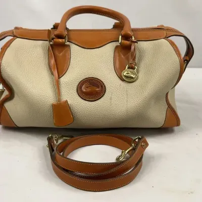 Vintage Dooney & Bourke All Weather Leather satchel bag in cream and tan, featuring a matching detachable shoulder strap, brass...