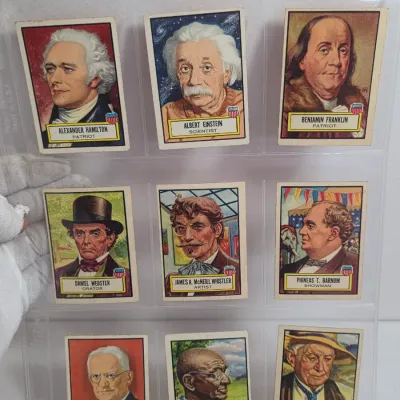 Sale Photo Thumbnail #7: Collection of nine vintage Fleer "Famous Americans" trading cards from 1952, featuring historical figures like Albert Einstein, Benjamin Franklin, and George Washington Carver, displayed in a plastic sleeve.