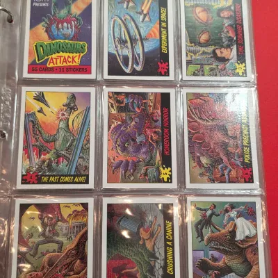 Sale Photo Thumbnail #10: A collection of vintage 1988 Topps Dinosaurs Attack! trading cards, numbered 1 through 9, displayed in a plastic binder sleeve.