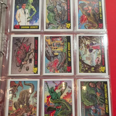 Sale Photo Thumbnail #12: A collection of vintage Dinosaurs Attack! trading cards by Topps, housed in a clear plastic binder sleeve.