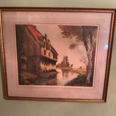 Framed landscape print depicting a European canal scene with historic buildings, housed in a gilded wood frame with a double mat.