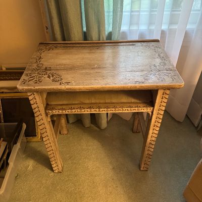 Vintage wooden school desk featuring hand-painted floral stenciling on the top and legs, with an open storage shelf underneath.