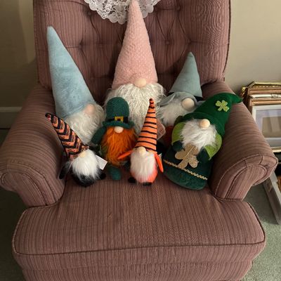 Collection of holiday-themed plush gnomes, including St. Patrick's Day and Halloween designs, displayed 