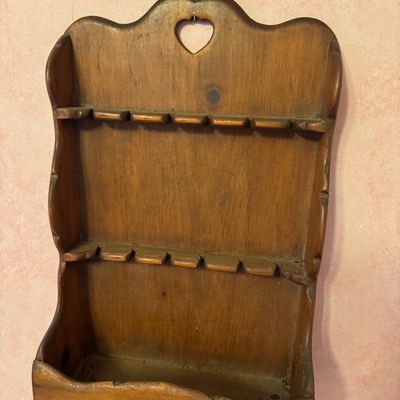 Vintage country-style wooden spoon rack with a heart cutout at the top, featuring two slotted shelves and a bottom bin.