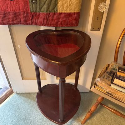 Heart-shaped wooden display table with a glass top, red velvet-lined interior, and a matching lower shelf.