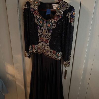 Vintage Bernadette black evening gown featuring a heavily beaded and sequined bodice with colorful floral and scrollwork details, circa...