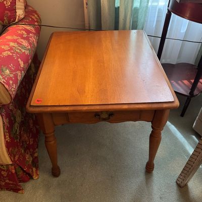 Vintage maple end table featuring a single drawer with a brass pull and turned legs.