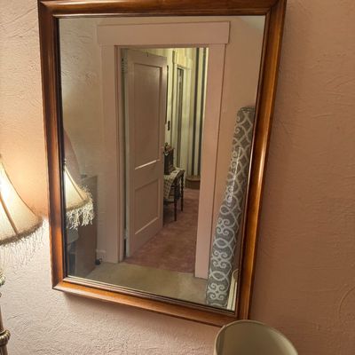 Rectangular wall mirror featuring a simple, classic wood frame. 