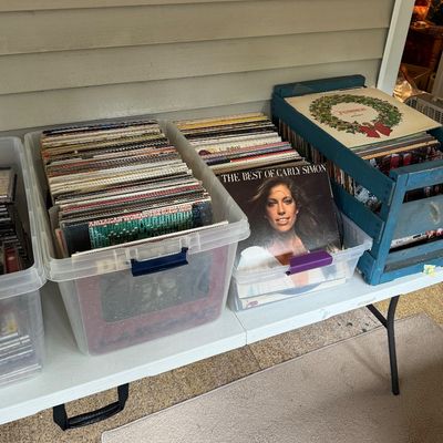 Collection of vintage vinyl records featuring classic rock and pop titles like Carly Simon and The Guess Who.