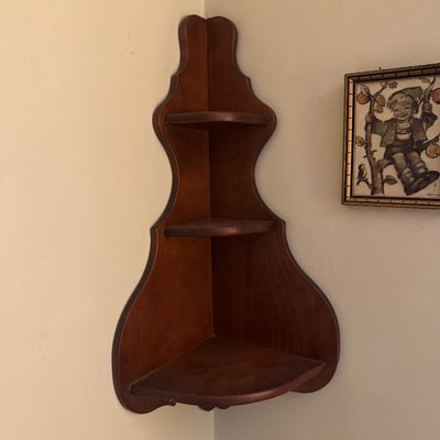 Vintage wooden three-tier corner shelf with a scalloped silhouette and warm brown finish.