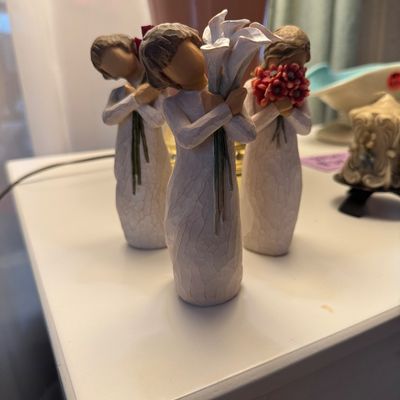 Three Willow Tree resin figurines by Susan Lordi, each depicting a girl holding flowers 
