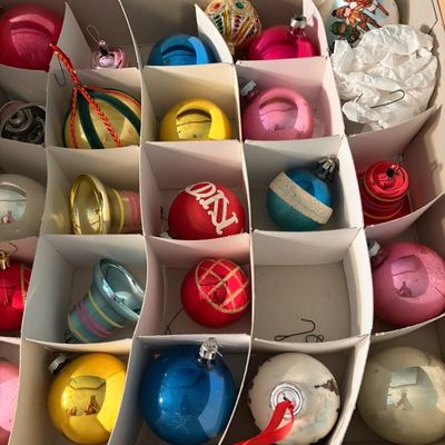 Sale Photo Thumbnail #89: Collection of vintage glass Christmas ornaments, including colorful balls, bells, and hand-painted designs, stored in a cardboard organizer box.