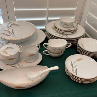 Sale Photo Thumbnail #42: Vintage mid-century modern fine china dinnerware set featuring a gold and grey wheat motif with gold trim, including plates, bowls, cups, saucers, a covered casserole dish, and serving pieces.