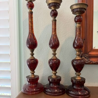 Sale Photo Thumbnail #41: Trio of graduated faux-amber or resin candlesticks with ornate brass accents and bases, in a traditional style.