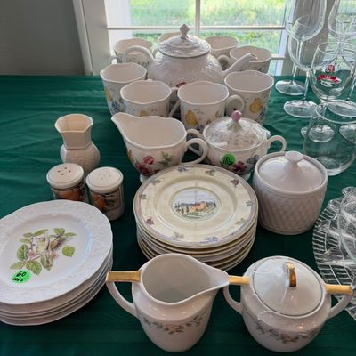 Sale Photo Thumbnail #55: Assorted porcelain tea and dinnerware sets, including a floral teapot with matching cups, bird-themed plates, and a gold-trimmed creamer and sugar bowl set.