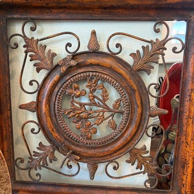 Sale Photo Thumbnail #47: Ornate Tuscan-style metal wall art featuring a central floral medallion, scrollwork, and a butterfly accent, housed in a distressed wooden frame.