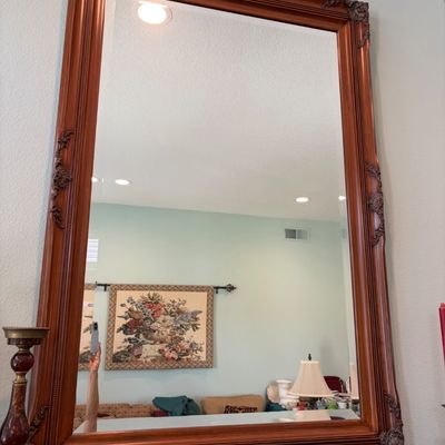 Sale Photo Thumbnail #46: Large rectangular wall mirror featuring a stained wood frame with ornate, carved corner and side details in a traditional style.