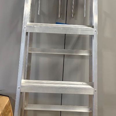 Sale Photo Thumbnail #73: Werner aluminum step ladder with a red plastic top cap and fold-out utility tray, showing light wear from use.