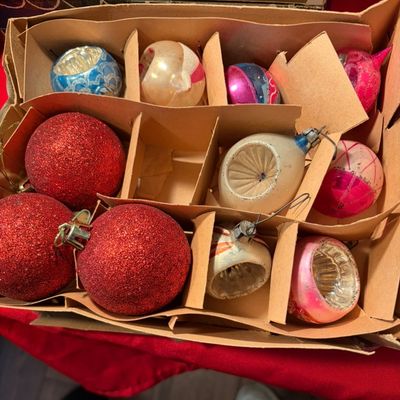 Sale Photo Thumbnail #93: Assorted vintage glass Christmas ornaments, including indented reflector and glittered styles, housed in a worn cardboard organizer box.