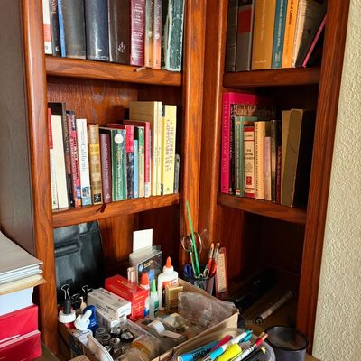 Sale Photo Thumbnail #83: Wooden built-in desk organizer and shelving unit filled with various books, office supplies, and craft materials.