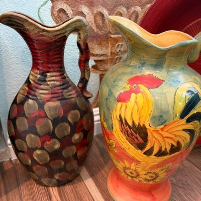 Sale Photo Thumbnail #51: Two decorative ceramic pitchers, including a textured brown and red vessel and a larger hand-painted pitcher featuring a vibrant rooster and sunflower motif.
