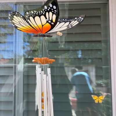 Sale Photo Thumbnail #25: Decorative wind chime featuring a large, colorful monarch butterfly topper and silver-toned metal tubes.