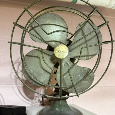 Vintage Kenmore model 124.8040 electric desk fan, featuring a green metal base, wire cage, and four aluminum blades.
