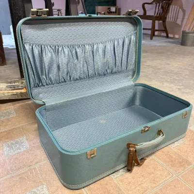 Vintage Samsonite hard-shell suitcase in light blue, featuring a patterned fabric interior with an elasticized pocket, circa 1960s.