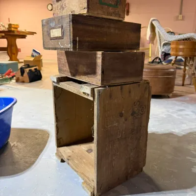 Stack of vintage wooden crates and drawers, showing natural wear and aged patina, suitable for rustic storage or decor.