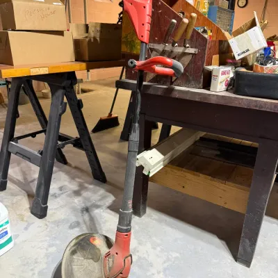 Black & Decker electric string trimmer with a red and black body, showing signs of use and wear.