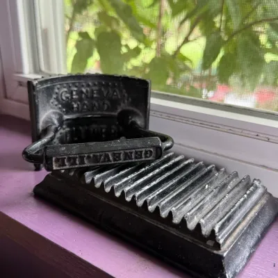 Antique cast iron Geneva Hand Fluter, featuring a corrugated base and matching rocker iron with embossed lettering, circa late 19th century.