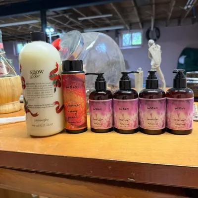 Assortment of hair and body care products, including a large bottle of Philosophy Snow Globe shampoo/shower gel, Wen Summer Honey Peach...