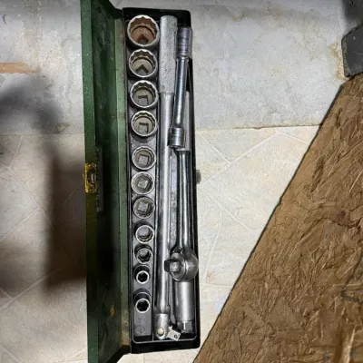 Vintage S-K Tools socket set in its original green metal case, including a ratchet, extension bars, and various socket sizes showing some...