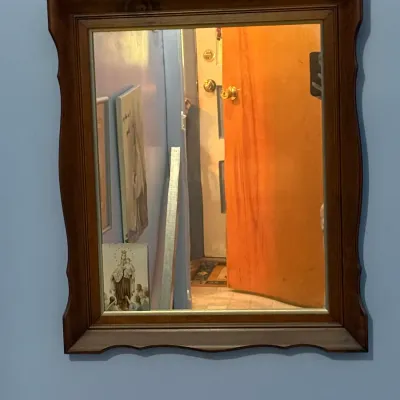 Vintage rectangular wall mirror featuring a scalloped dark wood frame with a gold-tone inner border.