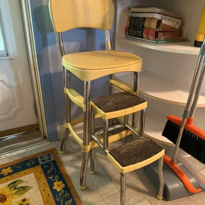 Vintage mid-century Cosco step stool chair with yellow vinyl upholstery, chrome frame, and pull-out steps.