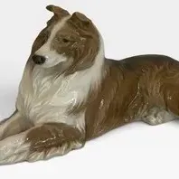 Vintage Royal Copenhagen Porcelain Reclining Collie Figurine - No. 1701 featuring a glossy glaze finish and detailed hand-painted features.